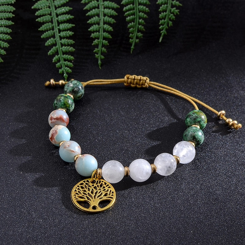 Ce bracelet "Sagesse" élégant représente bien plus que sa simple esthétique.  Il est parfait pour ceux qui cherchent à porter un rappel de sagesse avec eux tout au long de leur vie.  Notre bracelet "Sagesse" est un bijou exquis composé de jade blanc, de turquoise africaine, de perles de jaspe impérial, d'agate blanche et d'un médaillon symbolisant l'arbre de vie. Non seulement il est magnifique, seul ou superposé à d'autres pièces, mais il a une signification particulière qui durera des générations. 