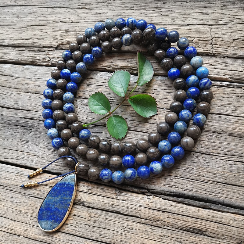 Ce puissant collier mala "confiance en soi" en Lapis Lazuli et Bronzite, lorsqu'il est porté avec intention, aide à se concentrer et à fixer des intentions positives pour soi-même qui cultivent l'amour de soi et la force de caractère.  Avec sa combinaison de couleurs audacieuses entre les pierres bleues lapis-lazuli et les accents bronzés de la bronzite, ce collier est un beau rappel de la confiance en son intuition et de la foi en ses décisions.