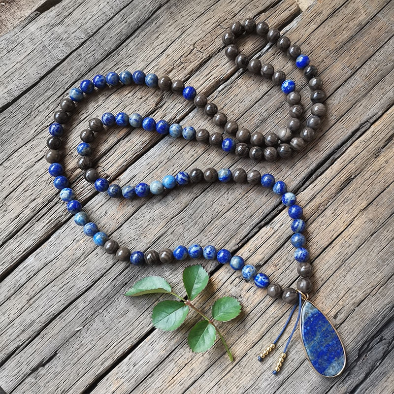 Ce puissant collier mala "confiance en soi" en Lapis Lazuli et Bronzite, lorsqu'il est porté avec intention, aide à se concentrer et à fixer des intentions positives pour soi-même qui cultivent l'amour de soi et la force de caractère.  Avec sa combinaison de couleurs audacieuses entre les pierres bleues lapis-lazuli et les accents bronzés de la bronzite, ce collier est un beau rappel de la confiance en son intuition et de la foi en ses décisions.