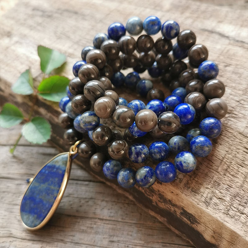 Ce puissant collier mala "confiance en soi" en Lapis Lazuli et Bronzite, lorsqu'il est porté avec intention, aide à se concentrer et à fixer des intentions positives pour soi-même qui cultivent l'amour de soi et la force de caractère.  Avec sa combinaison de couleurs audacieuses entre les pierres bleues lapis-lazuli et les accents bronzés de la bronzite, ce collier est un beau rappel de la confiance en son intuition et de la foi en ses décisions.