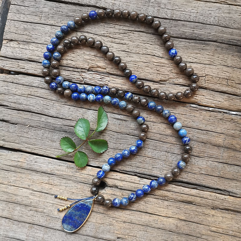 Ce puissant collier mala "confiance en soi" en Lapis Lazuli et Bronzite, lorsqu'il est porté avec intention, aide à se concentrer et à fixer des intentions positives pour soi-même qui cultivent l'amour de soi et la force de caractère.  Avec sa combinaison de couleurs audacieuses entre les pierres bleues lapis-lazuli et les accents bronzés de la bronzite, ce collier est un beau rappel de la confiance en son intuition et de la foi en ses décisions.