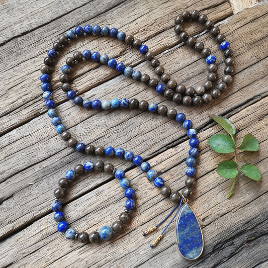 Ce puissant collier mala "confiance en soi" en Lapis Lazuli et Bronzite, lorsqu'il est porté avec intention, aide à se concentrer et à fixer des intentions positives pour soi-même qui cultivent l'amour de soi et la force de caractère.  Avec sa combinaison de couleurs audacieuses entre les pierres bleues lapis-lazuli et les accents bronzés de la bronzite, ce collier est un beau rappel de la confiance en son intuition et de la foi en ses décisions.